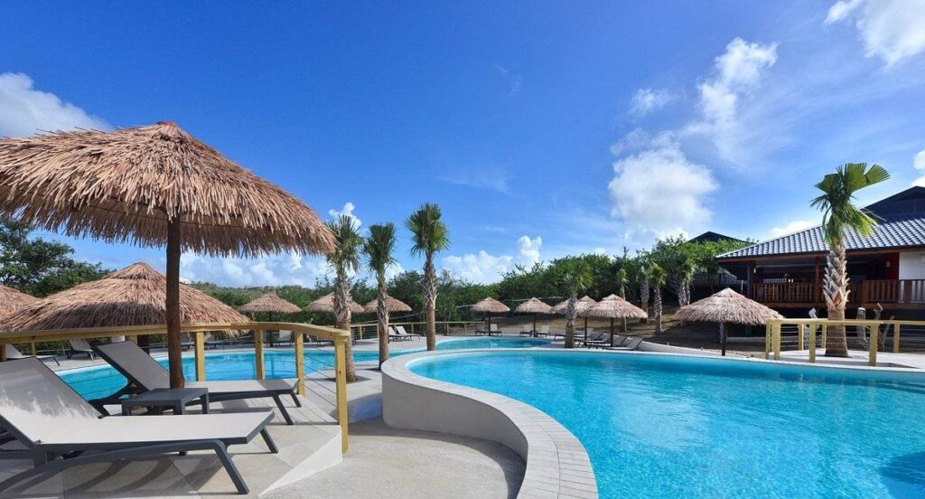 multiple thatched umbrellas around resort pool