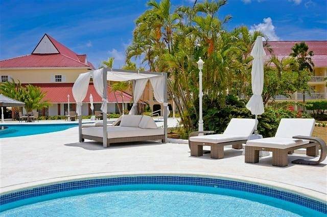 two pools with lounge chairs and lounge bed