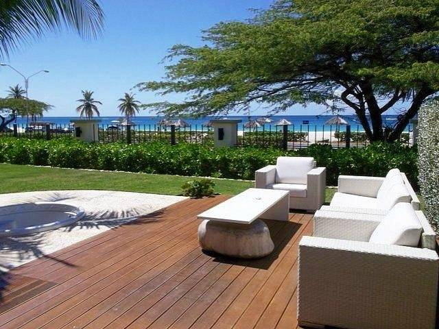 lounge chairs on wooden deck near ocean