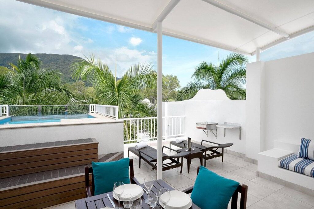 patio with lounge chairs and palm trees