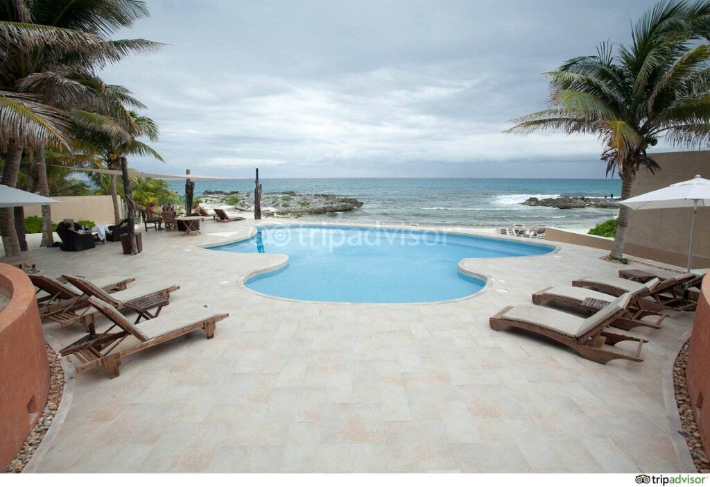 resort pool at ocean with lounge chairs