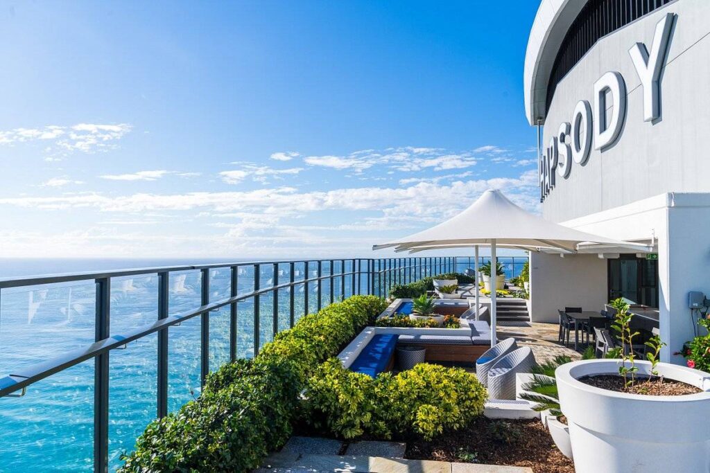 long patio with bushes at the ocean