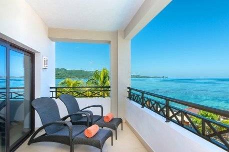two dark blue lounge chairs on patio overlooking ocean