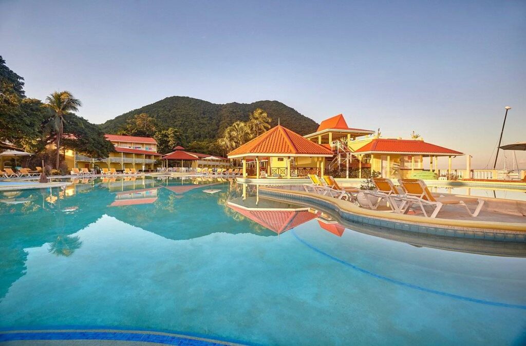large resort pool with lounge chairs and buildings