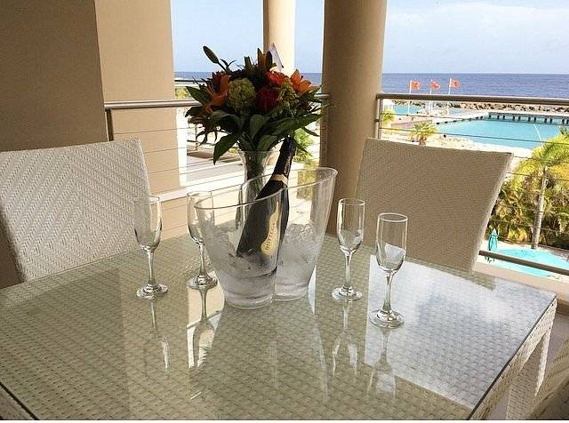 table on patio with wine and four glasses