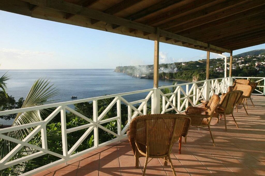 wicker chairs on covered patio in front of ocean