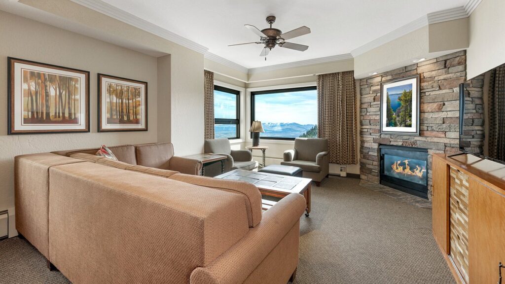 tan furniture in resort room with windows overlooking mountains