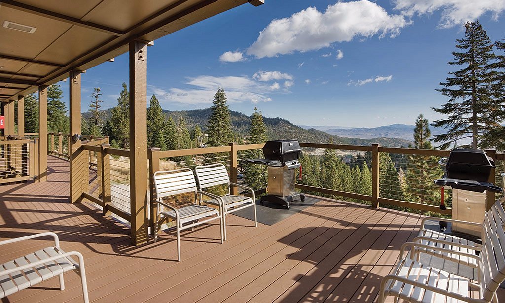 wooden patio with mountains and trees in background