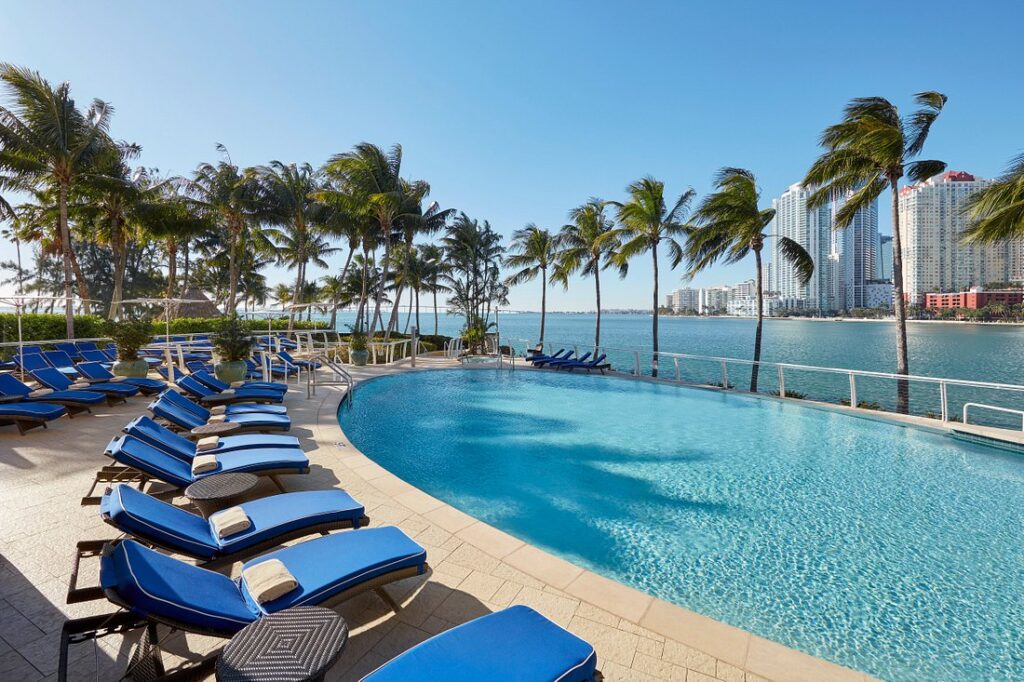 Mandarin Oriental, Miami pool lined with blue lounge chairs and palm trees