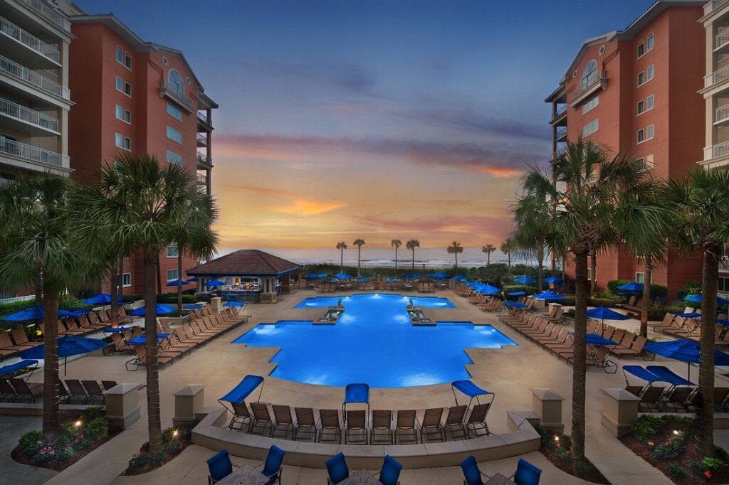 Marriott's OceanWatch Villas at Grande Dunes lighted pool between buildings at sunset