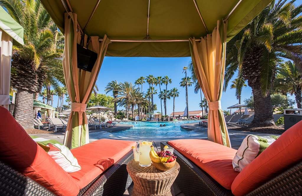 cabana with two orange lounge chairs facing pool