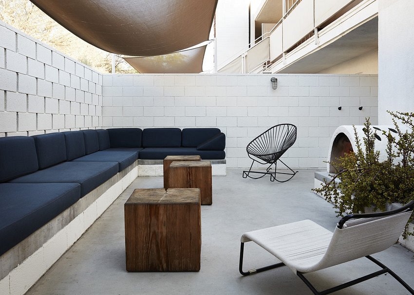 long semicircular blue couch with tow wood tables