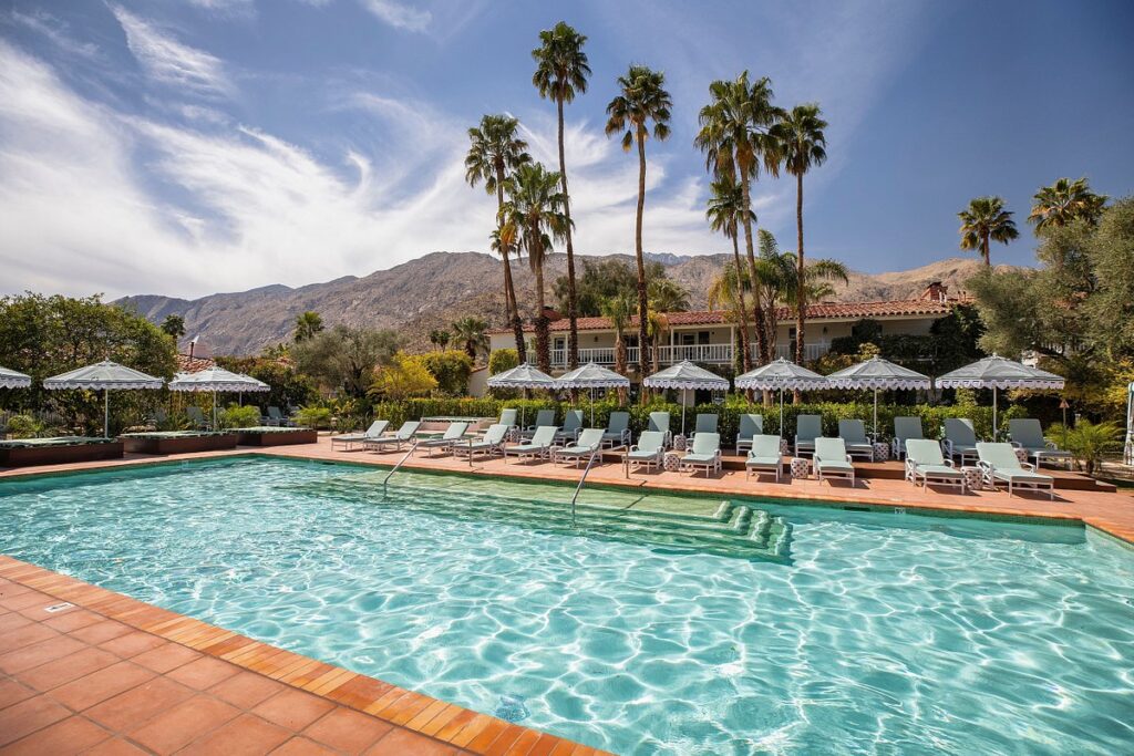 long resort pool with umbrellas and mountain in the background