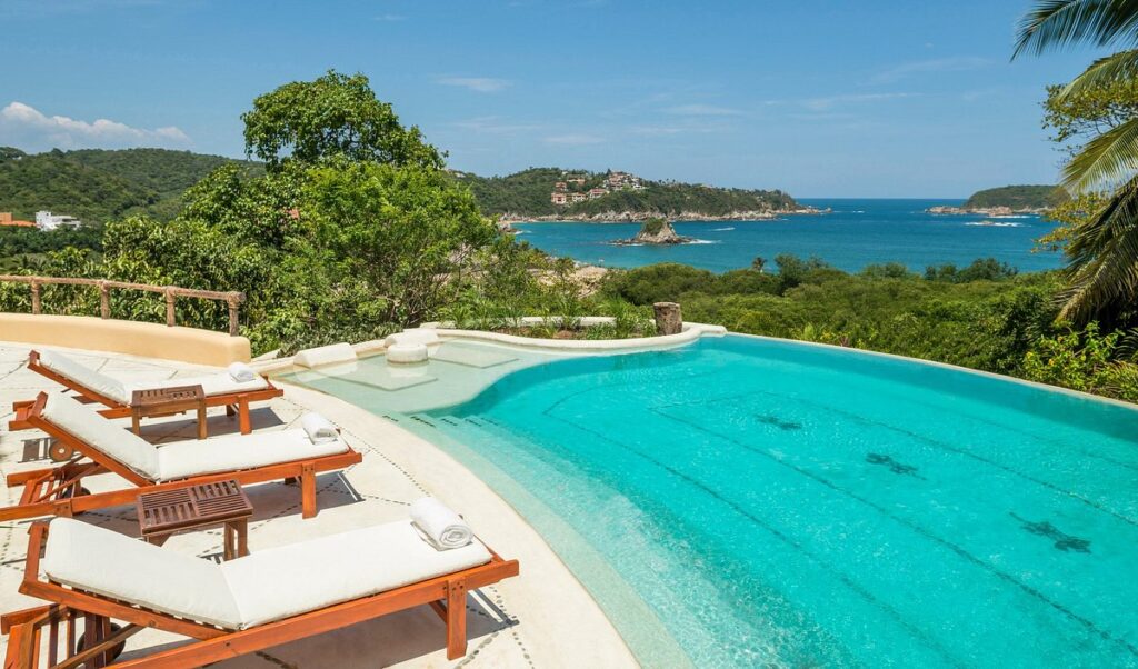 lounge chairs around tropical swimming pool