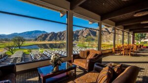 covered patio with brown chairs and mountains in background